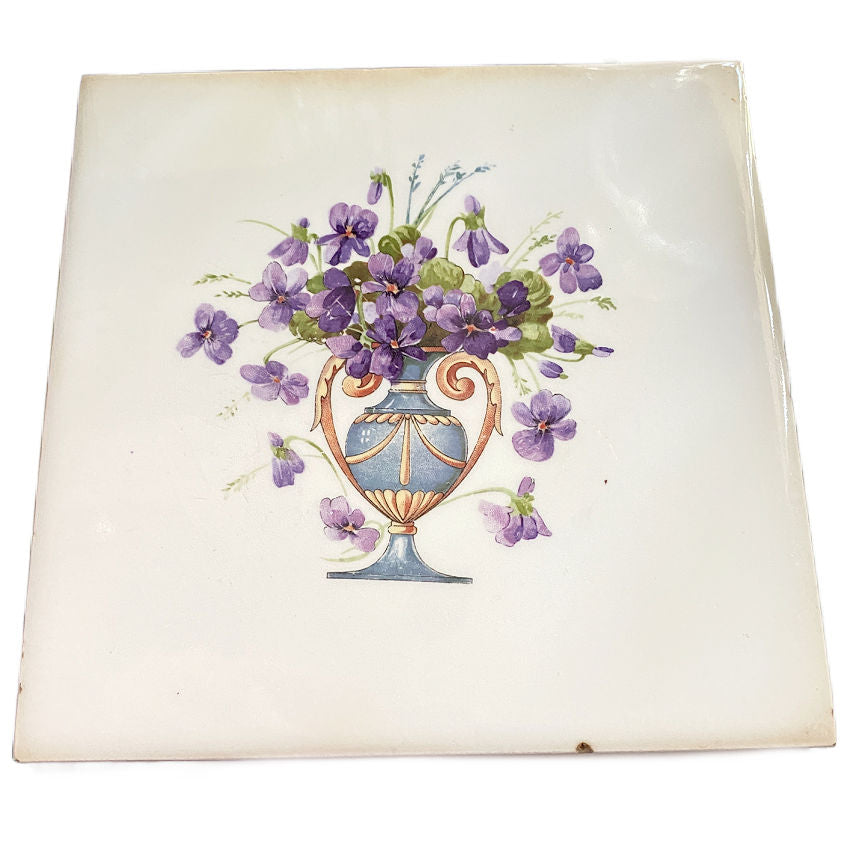 An antique American Wheeling ceramic tile featuring an urn of purple violets. Historic and collectible, perfect as a tea tile, centerpiece, or for a curated tile wall display.