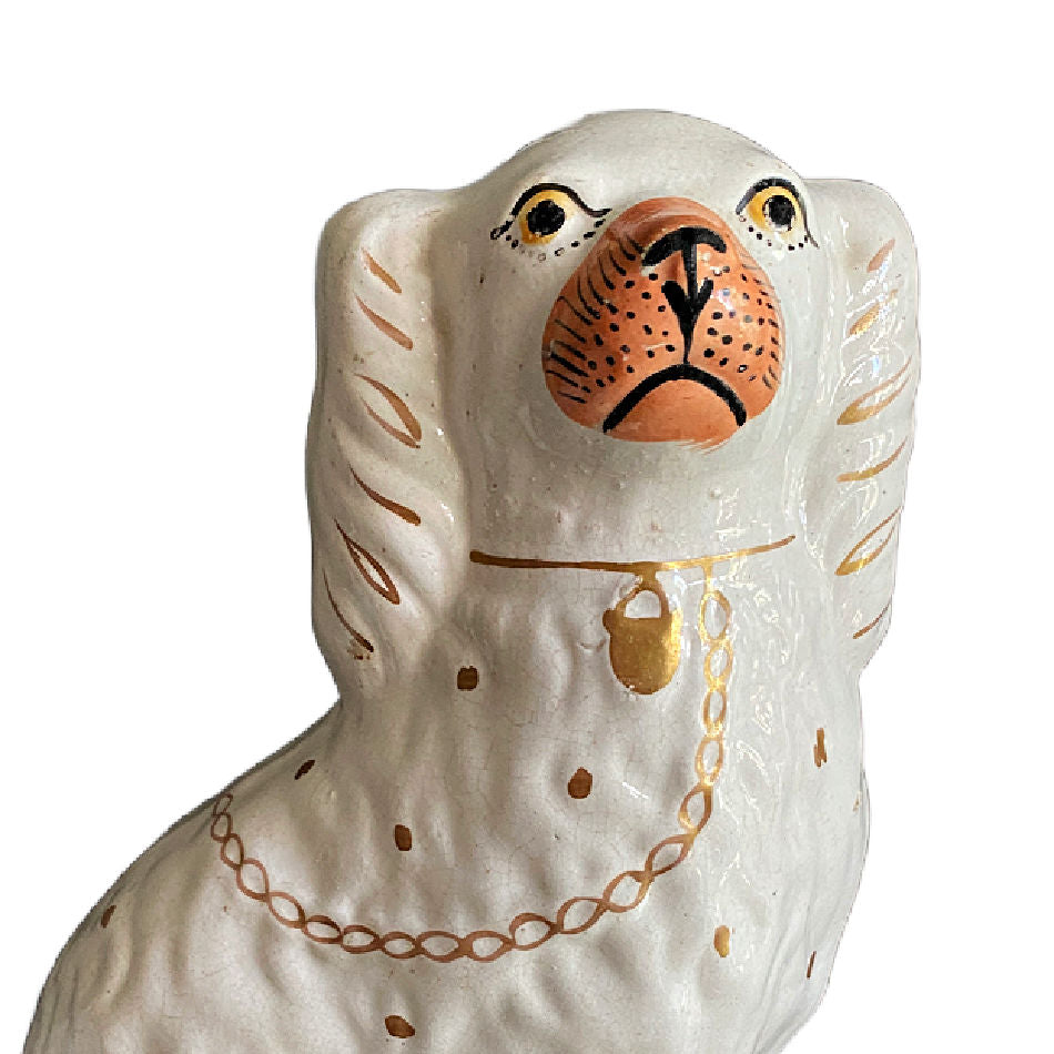 Close up of antique Staffordshire spaniel with gilt chain, padlock, and painted features