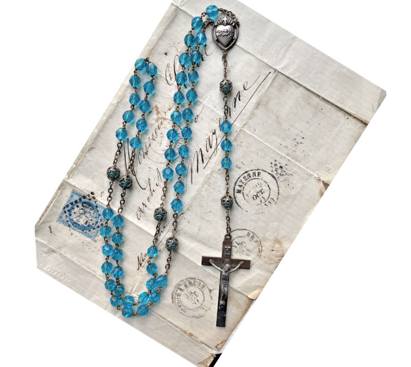 Close up hand faceted aquamarine rosary beads sparkling antique religious collectible