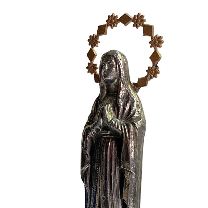 Close-up of antique French Lourdes Virgin Mary figure, showing gilded halo and delicate dark metal detailing.