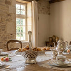 Styled antique basket filled with muffins in elegant dining room setting in a French country home