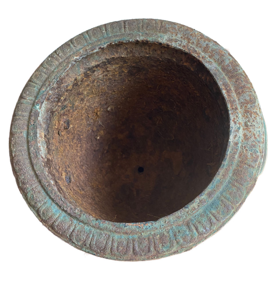 Aged cast iron urn with sculptural faces, verdigris patina top view