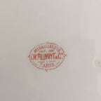 Clos up of the red Charles Pillivuyt and Cie Paris gold-medal factory mark on an antique French porcelain plate