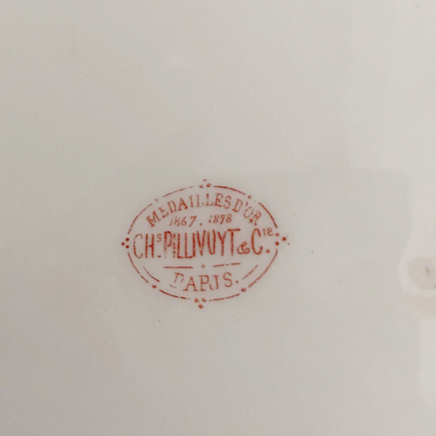 Clos up of the red Charles Pillivuyt and Cie Paris gold-medal factory mark on an antique French porcelain plate