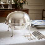 antique Edwardian silver plated revolving dome chafing dish on a table set with antque blue and white plates and silver