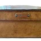 Close-up aged leather suitcase with worn leather and brass Ralph Lauren label