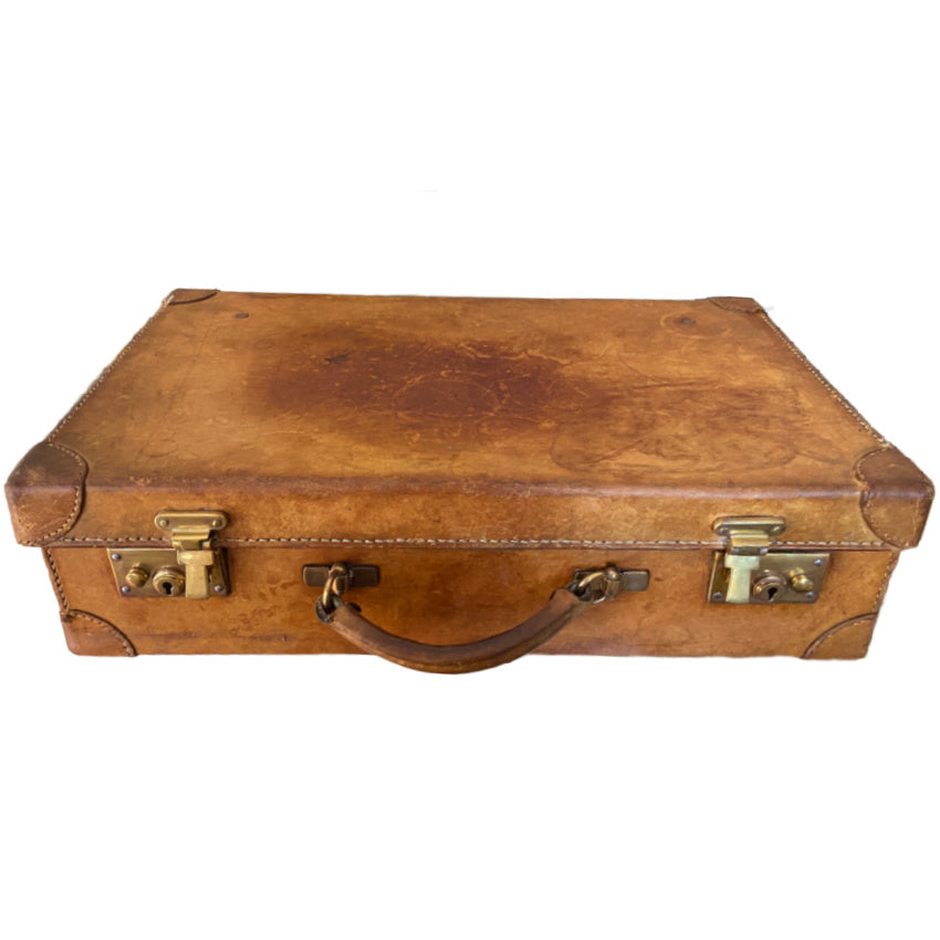 Close-up aged leather suitcase with worn corners and character
