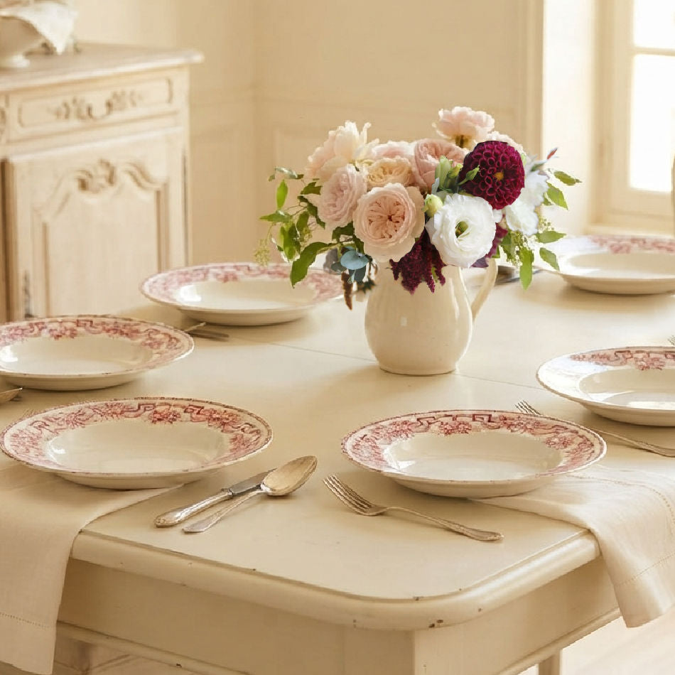 Antique French Athènes deep plates set on a table in a light-filled French country room