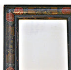 Close-up of red tulips and French Country mustard yellow, cream, green, and brown paint on an antique courting mirror