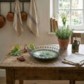 decorative French country basket pink fruit motif in French Country kitchen with herbs, linens and grapes