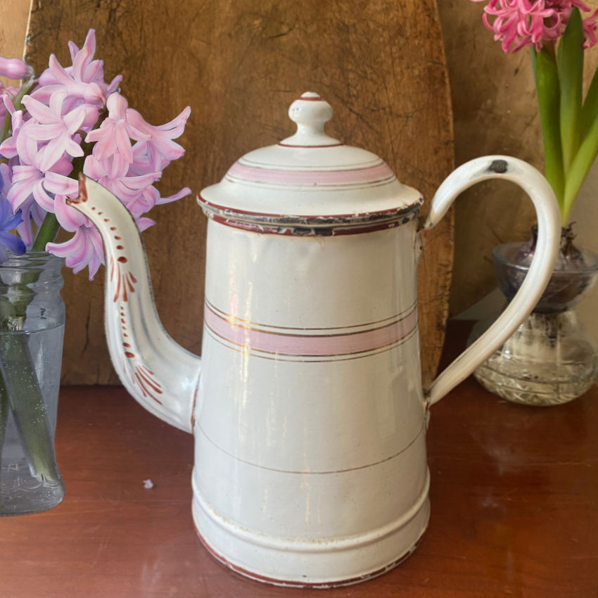 Antique French enamelware cafetière in white and pink with classic form, soft patina, and charming hand-painted details.