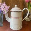 Antique French enamelware cafetière in white and pink with classic form, soft patina, and charming hand-painted details.