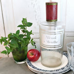French apothecary bottle styled with antique plates,an apple and mint
