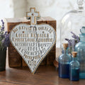 Antique French cemetery memorial plaque displayed on an antique wood desk with aqua glass bottles and leather books