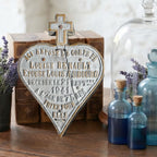 Antique French cemetery memorial plaque displayed on an antique wood desk with aqua glass bottles and leather books