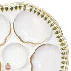 Side view of off-white Théodore Haviland Limoges oyster plate with green rims and gilt sponged detail
