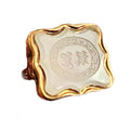 Close-up of white agate seal with Greek key border and engraved initials