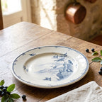 Antique Gien birds plate in blue and white in French itchen on the table with blueberries and linen napkin