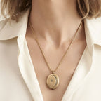 Antique crescent moon locket necklace worn alone on an open neckline