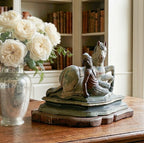 Antique hand-carved wooden horse and rider sculpture with aged brown, green, and blue-green paint on a stepped base on French desk in gracious home