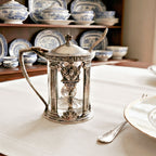 Antique Hotel Deshler silver plate mustard pot with original glass liner and spoon on table with blue and white antique porcelain