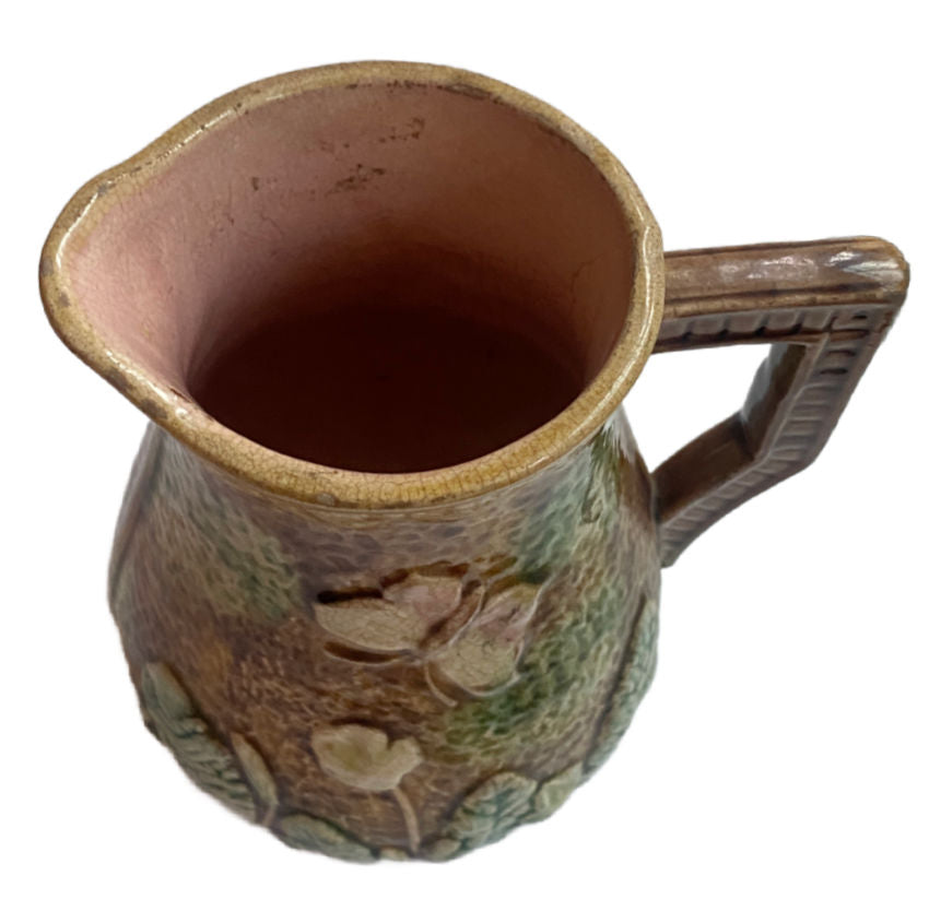 Antique French Majolica Pitcher with violets and butterflies, pink interior and aged patina—romantic 19th-century French country charm.