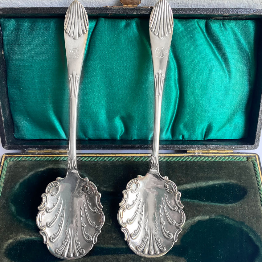 A charming pair of antique silver-plated jam spoons, monogrammed “D” and hand-engraved with rococo shell and leaf motifs. In their original case, with green silk and velvet lining.