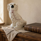 19th century English Staffordshire dog with pink lustre collar and chain on antique French Country Commode with antique French linen and leather book