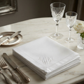 Antique embroidered linen napkins with MWA monogram styled on elegant marble table