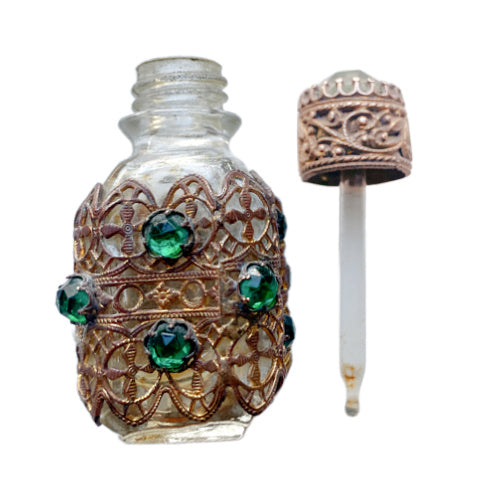 Exquisite Art Deco miniature perfume bottle adorned with emerald glass jewels and intricate gilt filigree. A romantic collector’s treasure of timeless elegance.