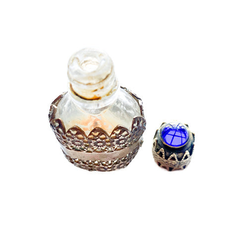 Exquisite Art Deco miniature perfume bottle with sapphire blue glass jewel and ornate gold filigree lid. A rare antique vanity treasure of timeless elegance.