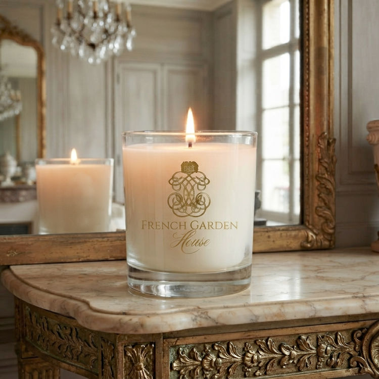 Luxury scented candle glowing on an antique French mantel beneath a gilt mirror
