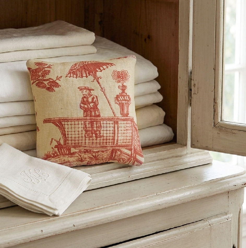 Chinoiserie linen lavender sachet for French antique linens styled with a stack of tablecloths and napkins in a line press
