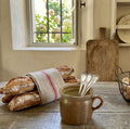 Antique South of France confit pot with warm greige glaze in French country kitchen holding silver spoons