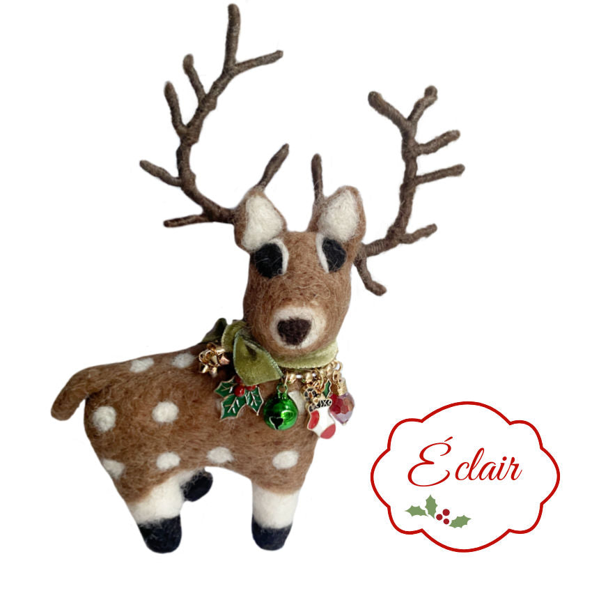 Our Éclair Holiday Felted Reindeer with Charms Ornament is a stylish young lady. Wearing a christmas charm necklace with enameled charms and a green bell