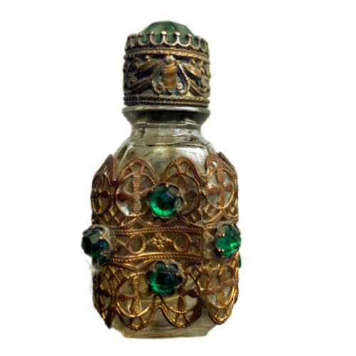 Exquisite Art Deco miniature perfume bottle adorned with emerald glass jewels and intricate gilt filigree. A romantic collector’s treasure of timeless elegance.
