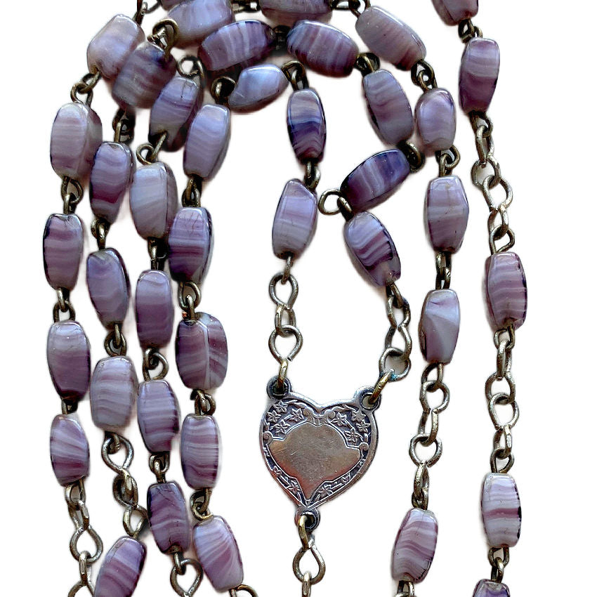 Close-up of faceted swirled amethyst-colored rosary beads