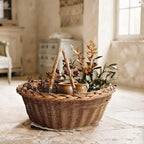French willow market basket with swing handles styled with leafy branches, French pottery, and a linen towel in a French country interior.
