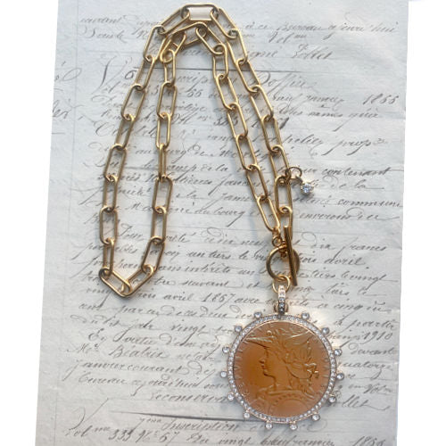 French coin medallion necklace on a bold gold paperclip chain. Elegant, sculptural and timeless with refined European appeal.