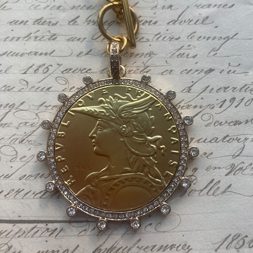 French coin medallion necklace on a bold gold paperclip chain. Elegant, sculptural and timeless with refined European appeal.