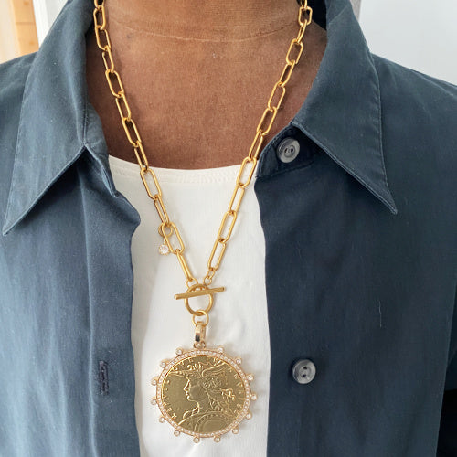 French coin medallion necklace on a bold gold paperclip chain. Elegant, sculptural and timeless with refined European appeal.