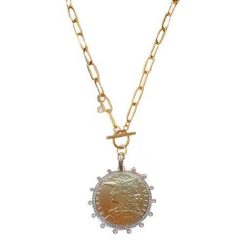 French coin medallion necklace on a bold gold paperclip chain. Elegant, sculptural and timeless with refined European appeal.
