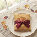 French linen with small autumn rose bouquet tied with silk ribbon, luxury styled on plate