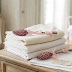French lavender wands set of two with rose ribbon on a stack of antique french linens