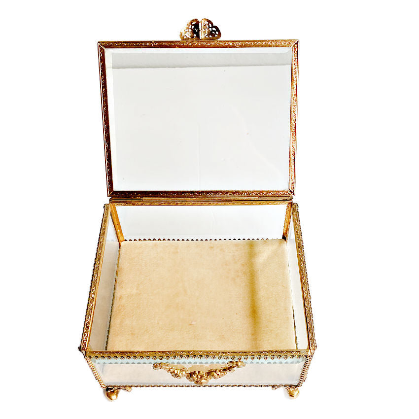 A rare gilt jewelry casket featuring heavy beveled glass panels, Rococo-style feet, and delicate rose garland detailing, and the original cushion opened.