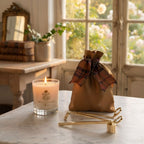 Gold Candle Care Kit with brass candle accessories beside a candle near a French window overlooking a garden