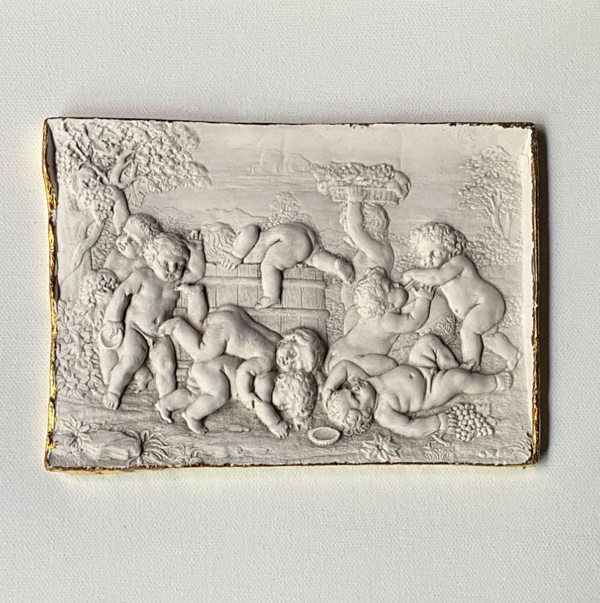 Close detail of cherub relief showing soft aged plaster surface