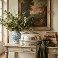 Antique Scottish silver plate meat dome styled on a hall table with fall leaves, green wool cloth and antique books
