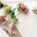Soft, luxurious 1½-inch silk-feel ribbon in Blush Petal. Elegant Parisian trim for gift wrapping, décor, and couture-inspired creations, with pink flowers and wedding invitation in gold.