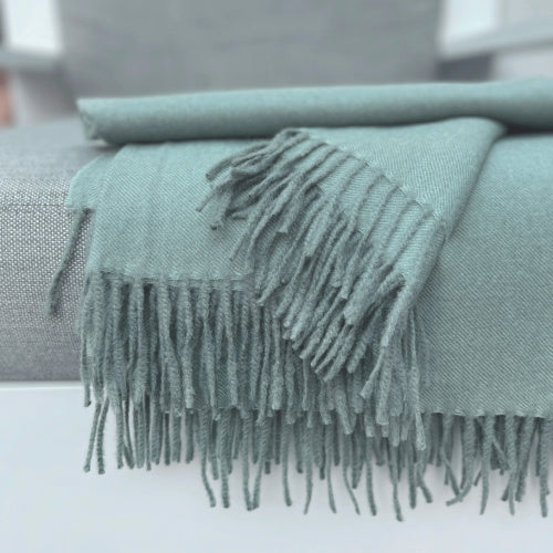 Indulge in this handwoven Celadon Mist alpaca throw, crafted from the finest baby alpaca for unmatched softness, warmth, and timeless sophistication.